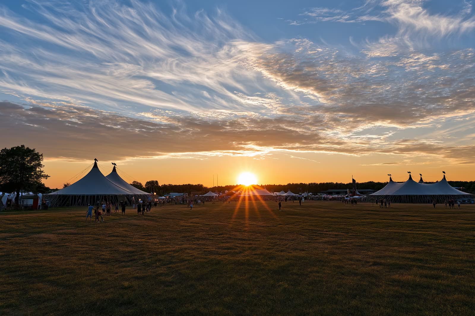 Zirkuszelte auf einem offenen Feld unter dem Sommerabendhimmel Berlins.