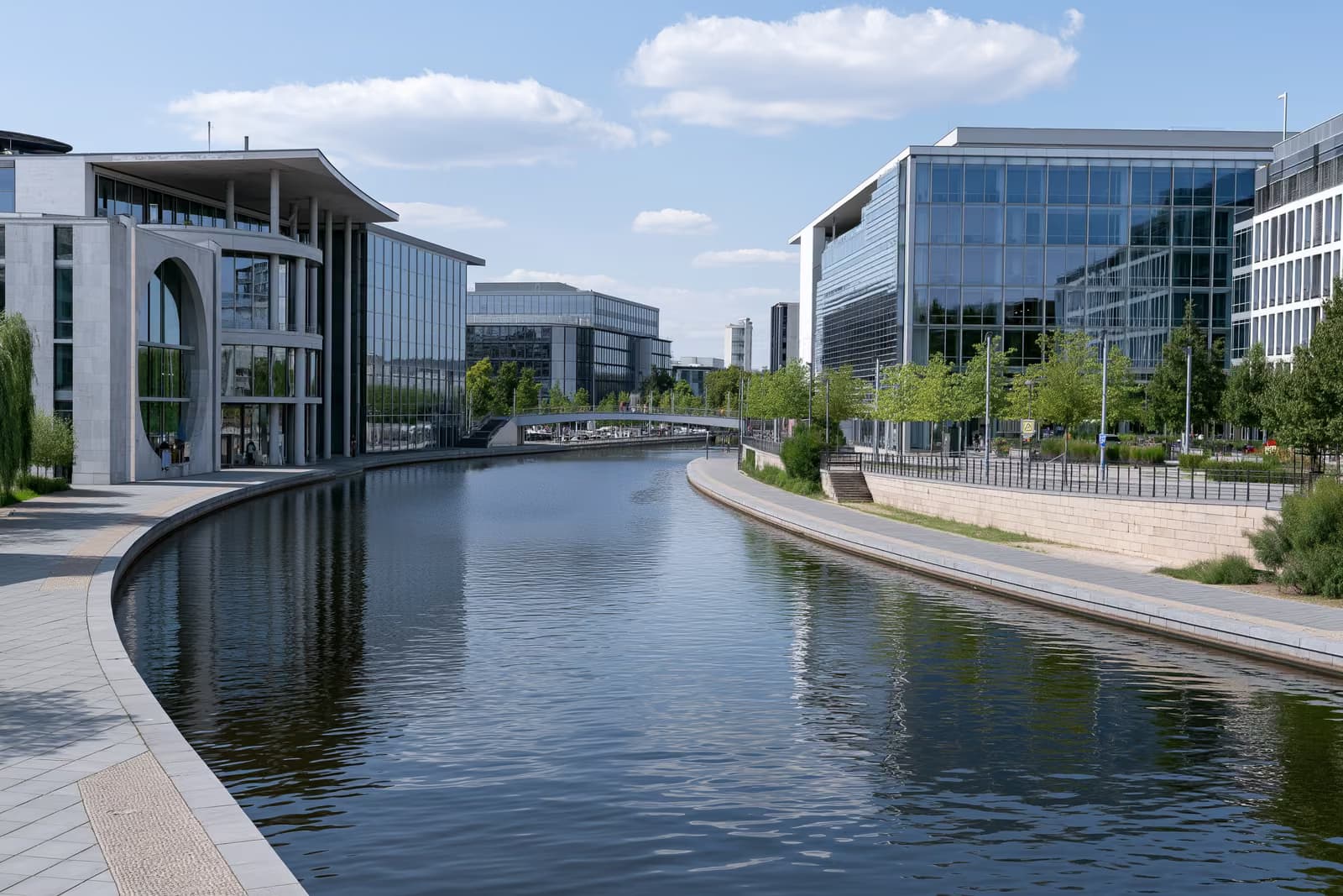 Das deutsche Regierungsviertel in Berlin unter strahlend blauem Sommerhimmel, vom anderen Flussufer aus gesehen.