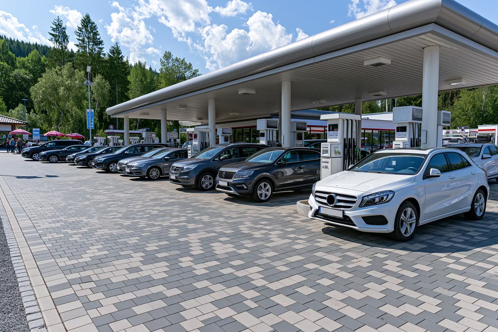 Eine Reihe von Zapfsäulen an einer deutschen Tankstelle an einem hellen Sommermorgen.