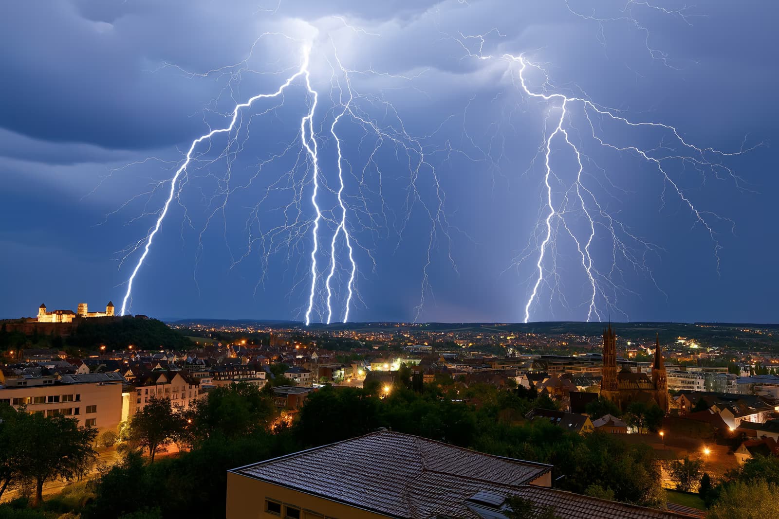Eine dramatische Gewitterzelle über Nürnberg mit Blitzen über dem Schloss und den Kirchtürmen der Stadt, während sich ein Regenvorhang nähert.