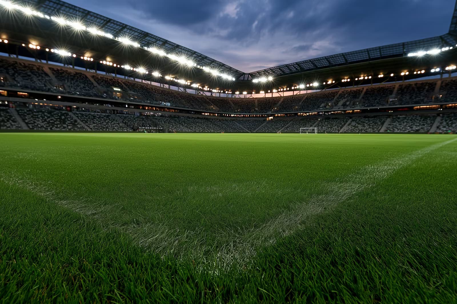 Ein Flutlicht-Fußballstadion in der Abenddämmerung vor einem Abendspiel.