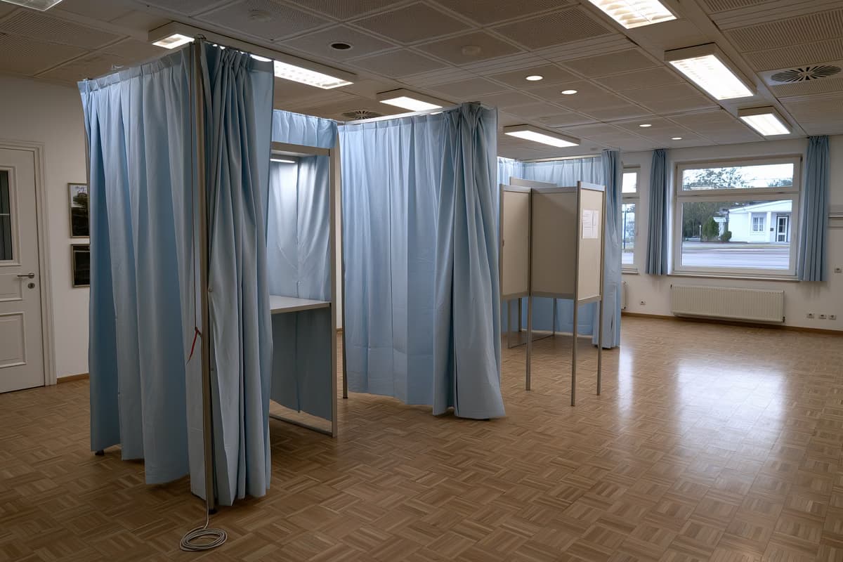 Eine leere Wahlkabine mit einem Bleistift an einer Schnur in einem deutschen Gemeindesaal